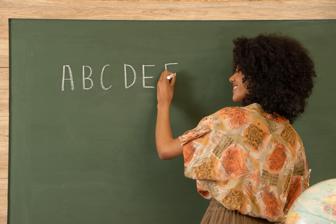 Female Teacher Writing Alphabet on the Chalkboard