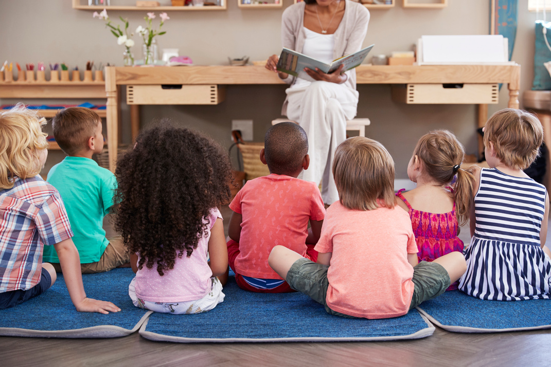 Teacher at Montessori School Reading to Children at Story Time